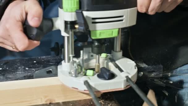 Közeli kép: egy ácsok keze dolgozik egy kézi elektromos vágó, hazai műhelyben. Befejező fa részek — Stock videók