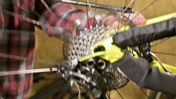 Крупный план установки заднего колеса горного велосипеда в мастерской по ремонту велосипедов. Ремонт велосипедов — стоковое видео