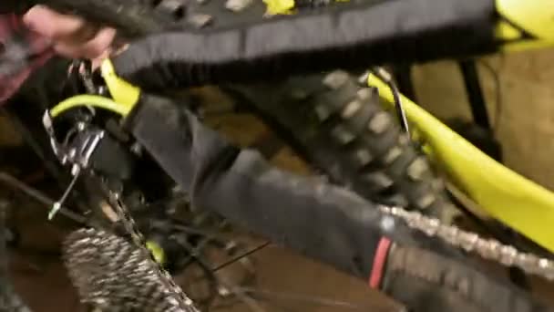 Close-up em uma loja de reparação de bicicletas, um mestre remove uma roda para manutenção. Reparação de bicicletas — Vídeo de Stock
