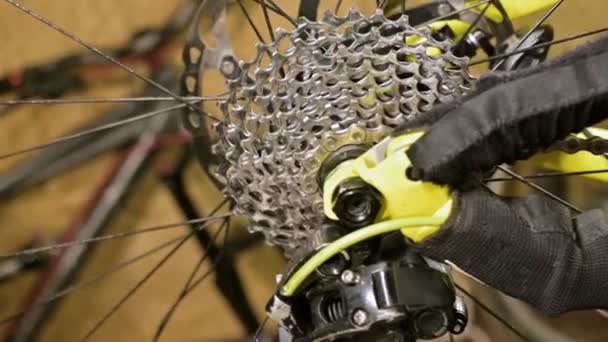 Primer plano del nudo del engranaje de la estrella del ciclismo al cambiar de marcha en un taller de reparación de bicicletas. Reparación de bicicletas — Vídeo de stock