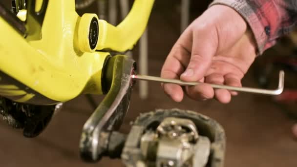 Primer plano en un taller de reparación de bicicletas el maestro retira los pedales para el mantenimiento. Reparación de bicicletas — Vídeo de stock
