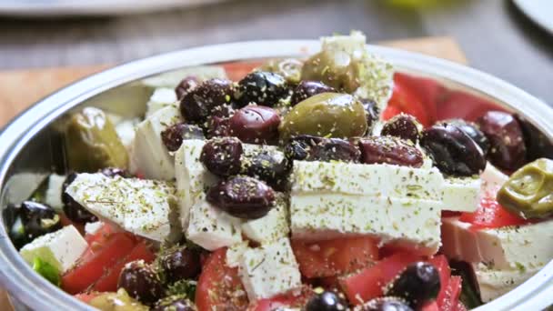 Közeli kép a fűszerezés manuális hozzáadása egy görög zöldségsaláta. Vegetáriánus konyha. Egészséges táplálkozás — Stock videók