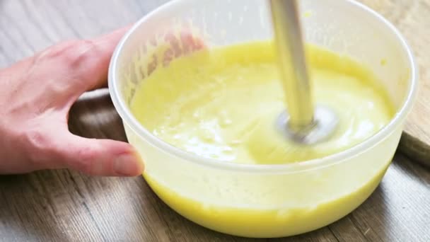 Primer plano batiendo mayonesa casera con una licuadora en un tazón de plástico — Vídeos de Stock