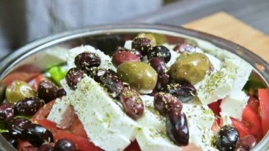 Baharat Yunan sebze salatası için el ile ekleme yakın çekim. Vejetaryen mutfağı. Sağlıklı gıda