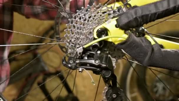 Instalación de cerca de la rueda trasera de una bicicleta de montaña en un taller de reparación de bicicletas. Reparación de bicicletas — Vídeos de Stock