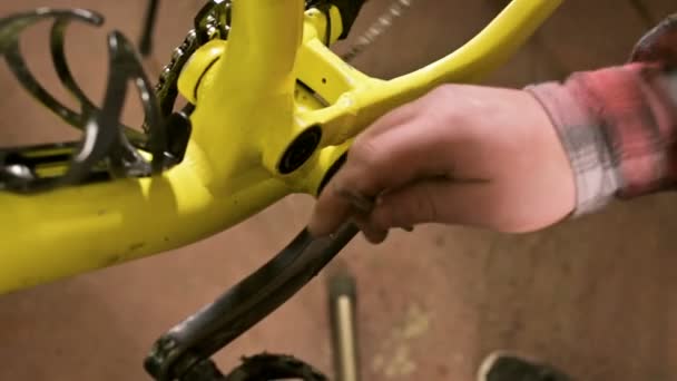 Primer plano en un taller de reparación de bicicletas el maestro retira los pedales para el mantenimiento. Reparación de bicicletas — Vídeos de Stock