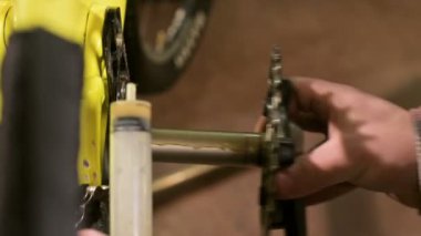Bisiklet tamir atölyesinde yakın çekim master bakım için pedal derlemenin şaft yağlar. Bisiklet tamir.