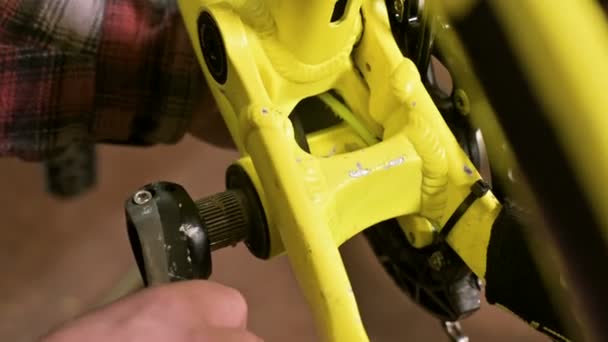 Крупным планом в мастерской по ремонту велосипедов мастер снимает педали для технического обслуживания. Ремонт велосипедов — стоковое видео