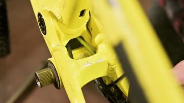 Närbild på en cykel verkstad master tar bort pedalerna för underhåll. Cykel reparation — Stockvideo