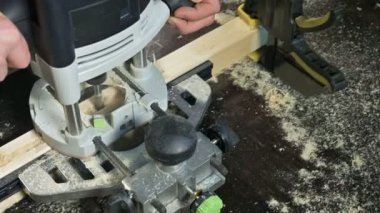 Bir ev atölye manuel bir elektrik kesici ile çalışan bir marangoz El Close-up. Ahşap parçaları bitirme.