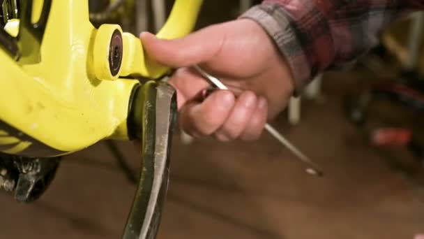 Close-up in een fietswinkel voor reparatie het model verwijdert de pedalen voor onderhoud. Fiets reparatie — Stockvideo