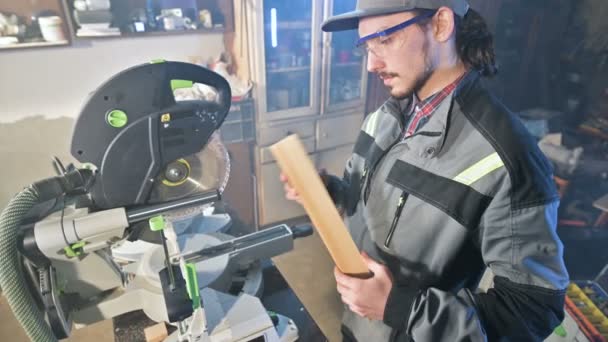 Un jeune menuisier installe une pièce en bois dans une scie circulaire. Atelier à domicile. Homme d'affaires débutant — Video