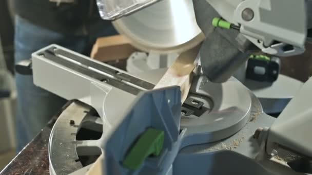 Gros plan d'un homme travaillant sur une machine avec une scie circulaire. Machine circulaire de coupe de billettes en bois — Video