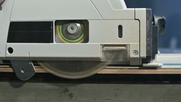 Close-up circular saw on the slider cuts off the edge of the chipboard plate — Stock Video