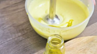 Plastik bir kabın içinde bir blender ile ev yapımı mayonez kırbaçlanan yakın çekim