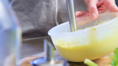 Plastik bir kabın içinde bir blender ile ev yapımı mayonez kırbaçlanan yakın çekim