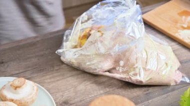 yakın çekim eller bir ördek veya pişirme için bir kaz ile plastik bir torbaya sarılmış bulunmaktadır. Beyaz soyunma mayonezli. Noel kaz ördek elma ile