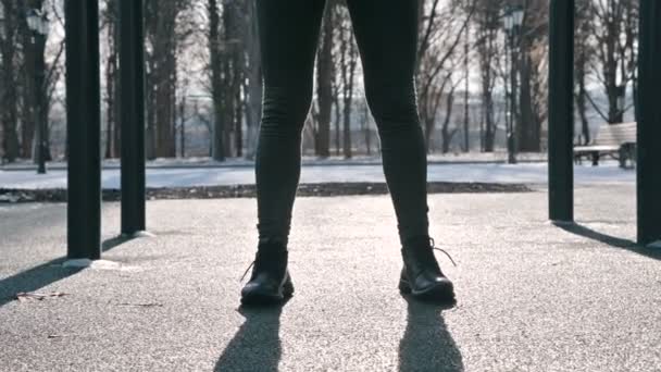 Nézd alatt a biztonsági öv. lábak sportos lány végez gyakorlatok edzés zömök, pad, egy napsütéses napon a téli — Stock videók