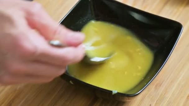 用与黄油和香料混合的勺子特写女性的手。家庭厨房。对于酱汁 — 图库视频影像