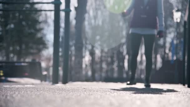 Alacsony szögben a nap ellen. A játszótéren a téli sportok lány teszi lunges lépdelt előre. — Stock videók