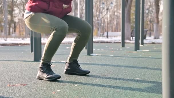 Vista debajo del cinturón. piernas chica atlética realiza ejercicios ejercicio almohadilla en cuclillas en el invierno en un día soleado — Vídeos de Stock