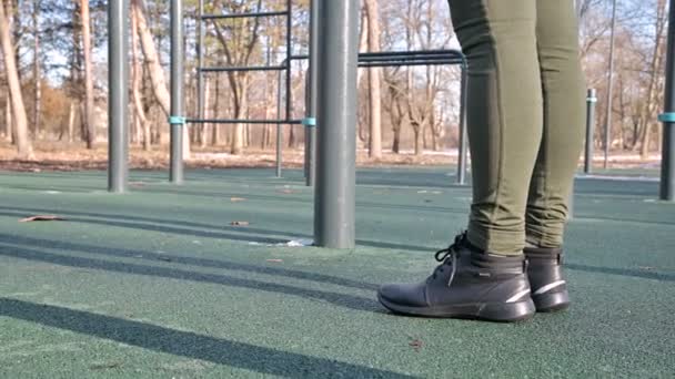 Close-up of girls legs in an open area for workout at the horizontal bar — Stock Footage Close-up of girls legs in an open area for workout at the horizontal bar Video Clip