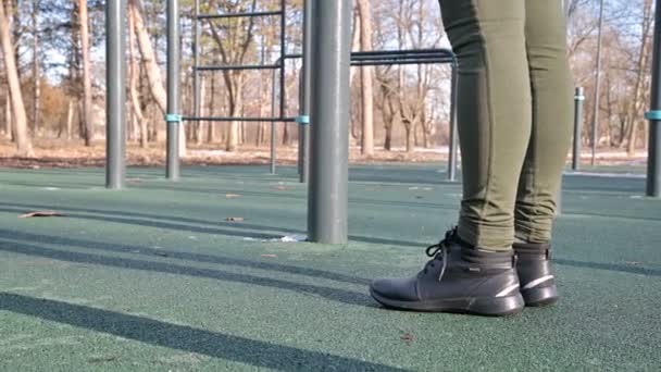 Close-up de pernas de meninas em uma área aberta para treino na barra horizontal — Vídeo de Stock