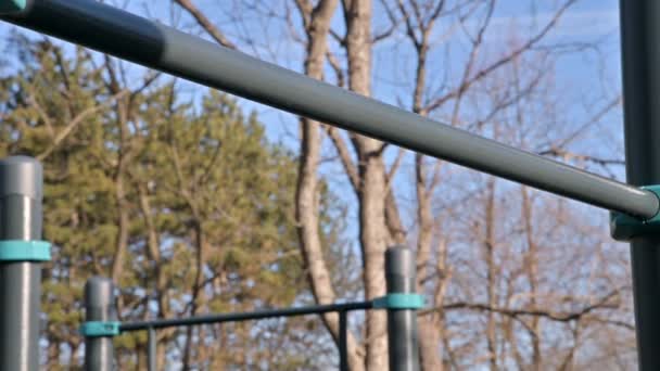 Close-up of the horizontal bar on the open area for workout. Girls hands jump on the crossbar — Stock Footage Close-up of the horizontal bar on the open area for workout. Girls hands jump on the crossbar Royalty Free Stock Footage