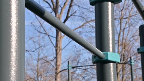 Close-up of the horizontal bar on the open area for workout. Girls hands jump on the crossbar — Stock Footage Close-up of the horizontal bar on the open area for workout. Girls hands jump on the crossbar Stock Footage