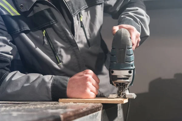 Close-up de carpinteiros mãos ferramentas elétricas de trabalho para o processamento de madeira. Poder Jigsaw — Fotografia de Stock