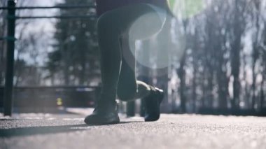 Düşük açılı güneş karşı. Kış spor kız oyun ileri uzun adımlarla lunges yapar.