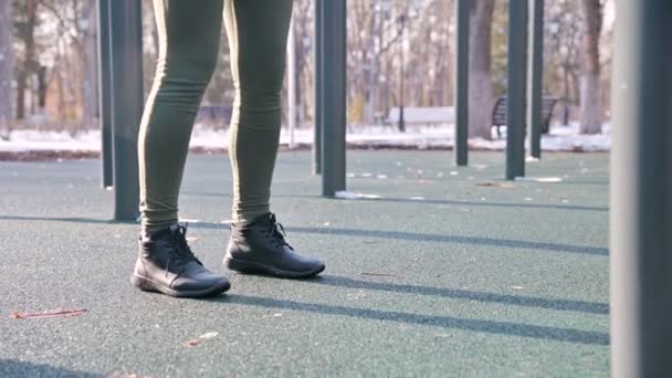 Vista debajo del cinturón. piernas chica atlética realiza ejercicios ejercicio almohadilla en cuclillas en el invierno en un día soleado — Vídeo de stock