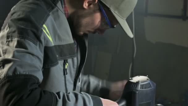 Close-up de uma mão carpinteiros trabalhando com um cortador elétrico manual em uma oficina em casa. Acabamento de peças de madeira — Vídeo de Stock