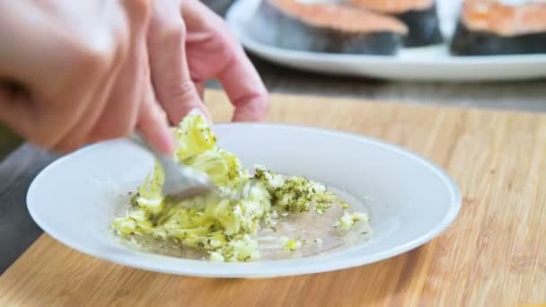 El primer plano de las manos femeninas con un tenedor revolvió la mantequilla con especias. Cocina casera. Para la salsa — Vídeos de Stock