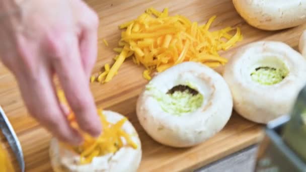 Close-up van vrouwelijke handen vulling verse porcini paddestoelen met saus en geraspte kaas op een protwin. Voorbereiding voor het roosteren in de oven van paddestoelen — Stockvideo