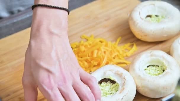 Close-up van vrouwelijke handen vulling verse porcini paddestoelen met saus en geraspte kaas op een protwin. Voorbereiding voor het roosteren in de oven van paddestoelen — Stockvideo