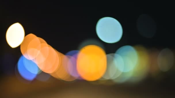 Luces bokeh de colores en la ciudad nocturna. círculos móviles de semáforos señales. Destacados noche desenfocada en la carretera de la ciudad — Vídeo de stock