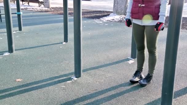 Close-up of girls legs on the open area for workout. Woman shakes the press hanging on the horizontal bar — Stock Footage Close-up of girls legs on the open area for workout. Woman shakes the press hanging on the horizontal bar Royalty Free Stock Video