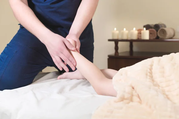 Zbliżenie: kręgarz mężczyzna ręce masażu łydek małe pacjenta. Mały chłopiec w recepcji procedury masażu w gabinecie fizykoterapii — Zdjęcie stockowe