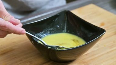 Close-Up eller bir kaşık tereyağı ve baharatlar ile karışık. Ev mutfak. Sos için