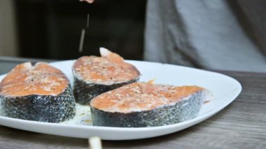 Taze balık hazırlar bir aşçı kız el yakın çekim somon limon suyu ile sulama alabalık. Limon ellerini sıkar. Sağlıklı yemek ve vegan ev yemekleri
