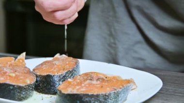Taze balık hazırlar bir aşçı kız el yakın çekim somon limon suyu ile sulama alabalık. Limon ellerini sıkar. Sağlıklı yemek ve vegan ev yemekleri