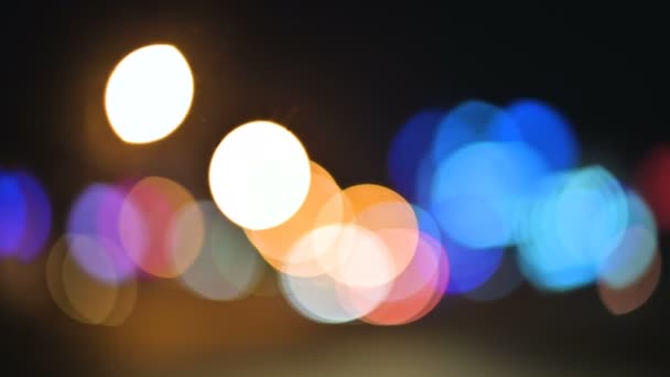 Farbige Bokeh-Lichter in der nächtlichen Stadt. Bewegte Kreise von Ampelsignalen. Nächtliche Schwerpunkte auf der Stadtstraße — Stockvideo