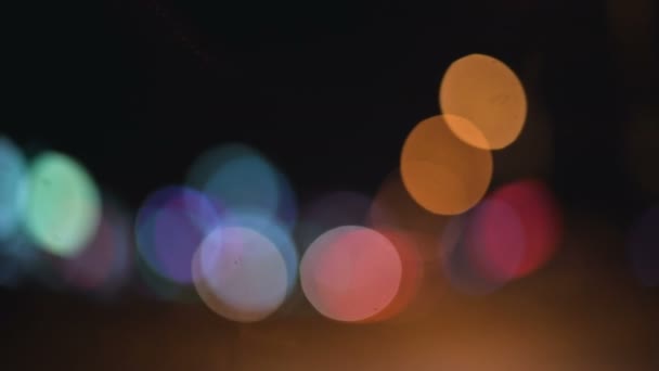 Цветные боке огни в ночном городе. движущиеся круги светофоров знаков. Расслабленные ночные огни на городской дороге — стоковое видео