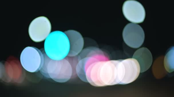 Lumières bokeh colorées dans la ville de nuit. cercles mobiles de feux de signalisation. Faits saillants de la nuit déconcentrée sur la route 