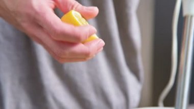 Sosu yapmak için siyah bir kapta limon kullanarak bir çatal ile yakın çekim kız sıkıyor