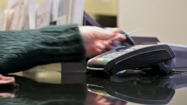 Yakın çekim terminal kartı okuyucu için kredi kartı ile ödeme. Bir kadının el bir mağazada terminal paypass ödeme için bir kart uygulayarak ödüyor. Bankacılık hizmetleri elektronik para. Banka kartı kullanmak