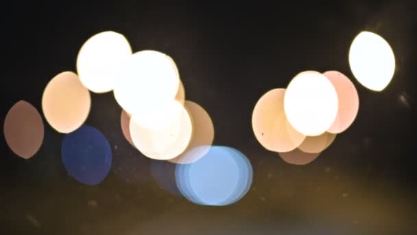 Farbige Bokeh-Lichter in der nächtlichen Stadt. Bewegte Kreise von Ampelsignalen. Nächtliche Schwerpunkte auf der Stadtstraße — Stockvideo