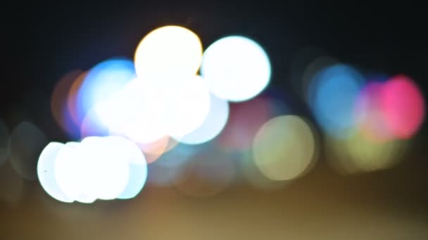 Gekleurde bokeh lichten in de stad van de nacht. bewegende cirkels van verkeerslicht lichten tekenen. Intreepupil nacht hoogtepunten op weg van de stad — Stockvideo