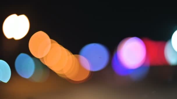 Lumières bokeh colorées dans la ville de nuit. cercles mobiles de feux de signalisation. Faits saillants de la nuit déconcentrée sur la route 